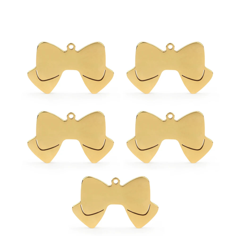 Lot de cinq pendentifs dorés en forme de nœud papillon sur fond blanc.