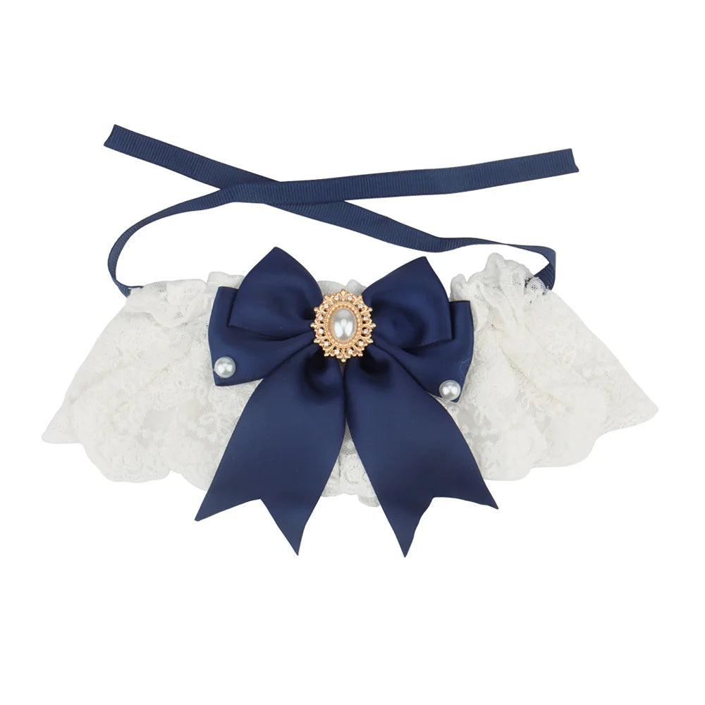 Collier chic pour chien en dentelle blanche avec nœud bleu marine, perles décoratives et bijou central.