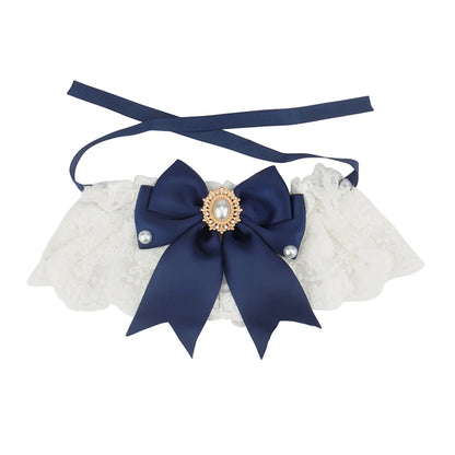 Collier chic pour chien en dentelle blanche avec nœud bleu marine, perles décoratives et bijou central.