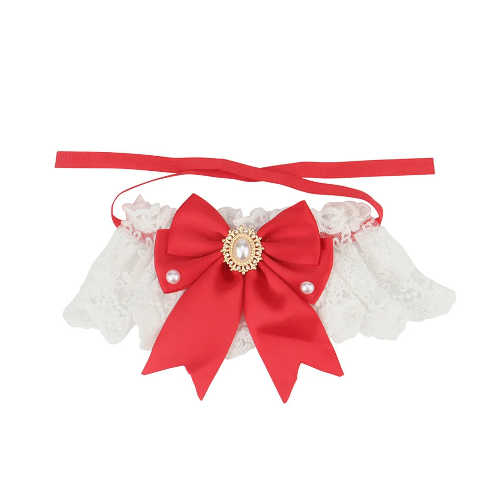 Collier chic pour chien en dentelle blanche avec nœud rouge, perles décoratives et bijou central.