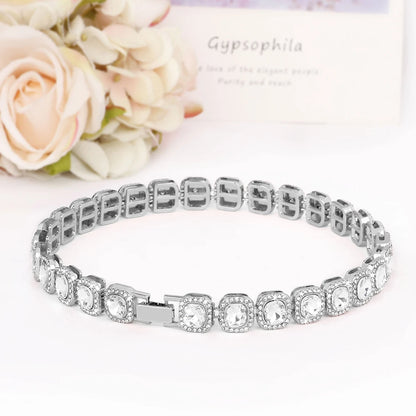 Collier argenté pour chien avec cristaux scintillants posé sur une surface blanche.