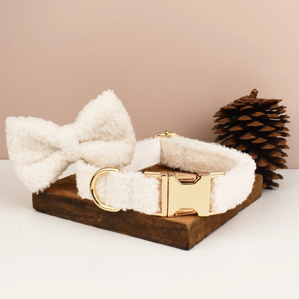 Collier blanc pour chien en tissu bouclette avec nœud papillon présenté sur un support en bois.