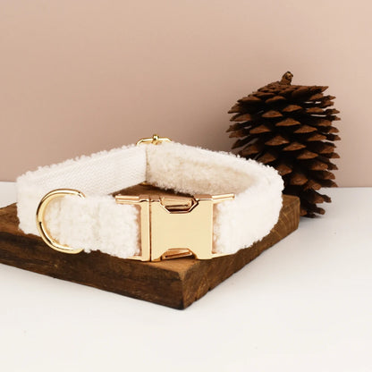 Collier blanc pour chien en tissu bouclette avec boucle dorée présenté sur un support en bois.