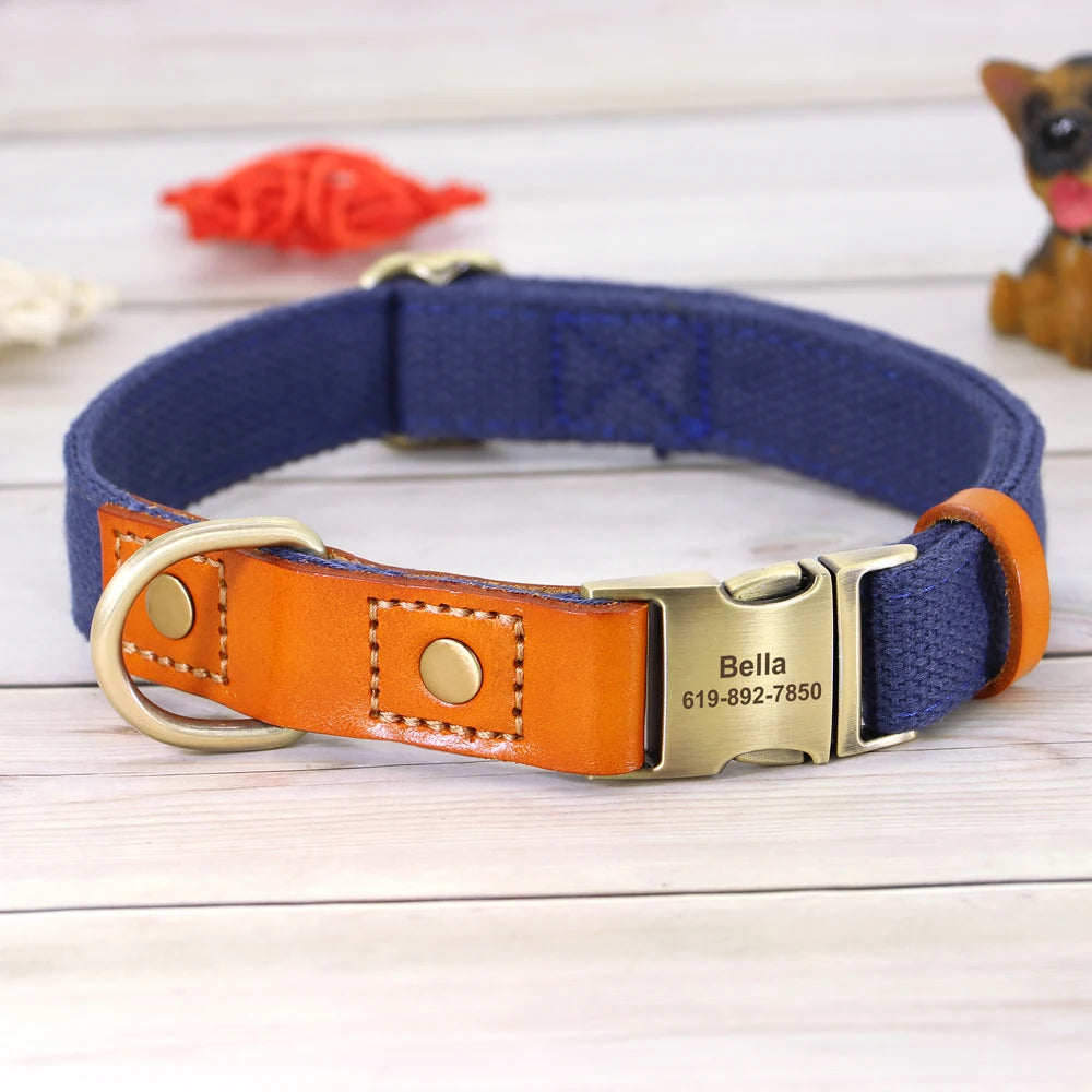 Collier bleu foncé cuir orange pour chien avec boucle métal gravée personnalisable et en anneau en D présenté sur un fond en bois gris.