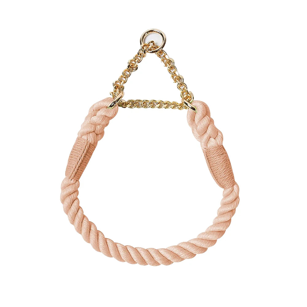 Collier rose pâle pour chien en corde de coton tressée avec chaîne métallique dorée sur fond blanc.