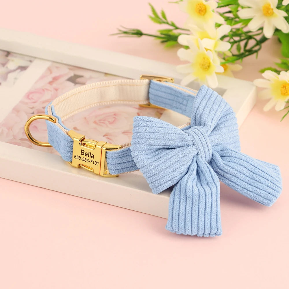 Vue du collier pour chien en coton doux bleu avec grand nœud papillon et plaque gravée personnalisée sur fond décoratif floral