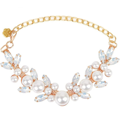 Collier pour chien avec perles blanches, pierres claires et chaîne dorée sur fond clair.