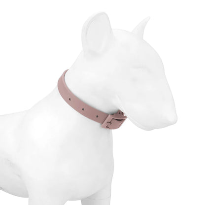 Collier pour chien en PVC imitation silicone rose poudre moyen porté sur un mannequin de chien blanc, vue de profil sur fond blanc, boucle à ardillon rectangulaire visible sur le côté.