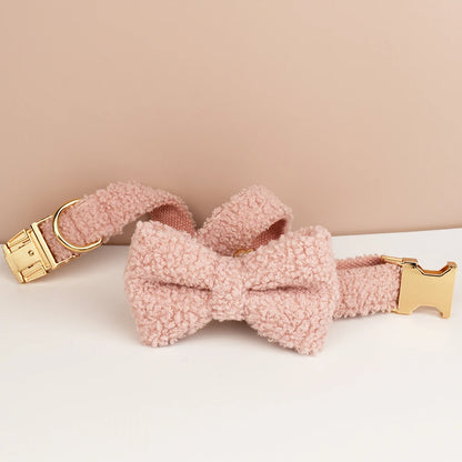 Collier chien bouclette rose avec boucle métal dorée enroulé sur fond rose et blanc.