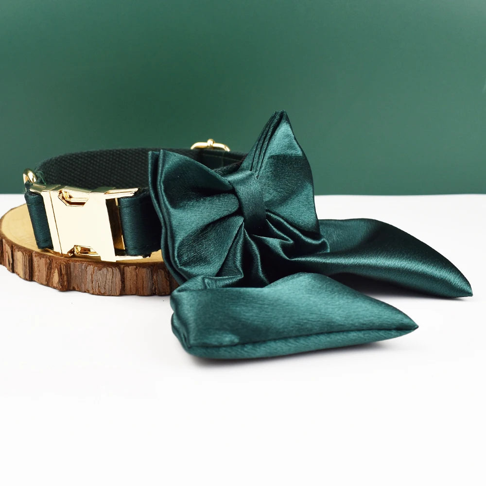 Collier vert foncé pour chien avec grand nœud détachable et anneau métal doré présenté sur un support en bois.