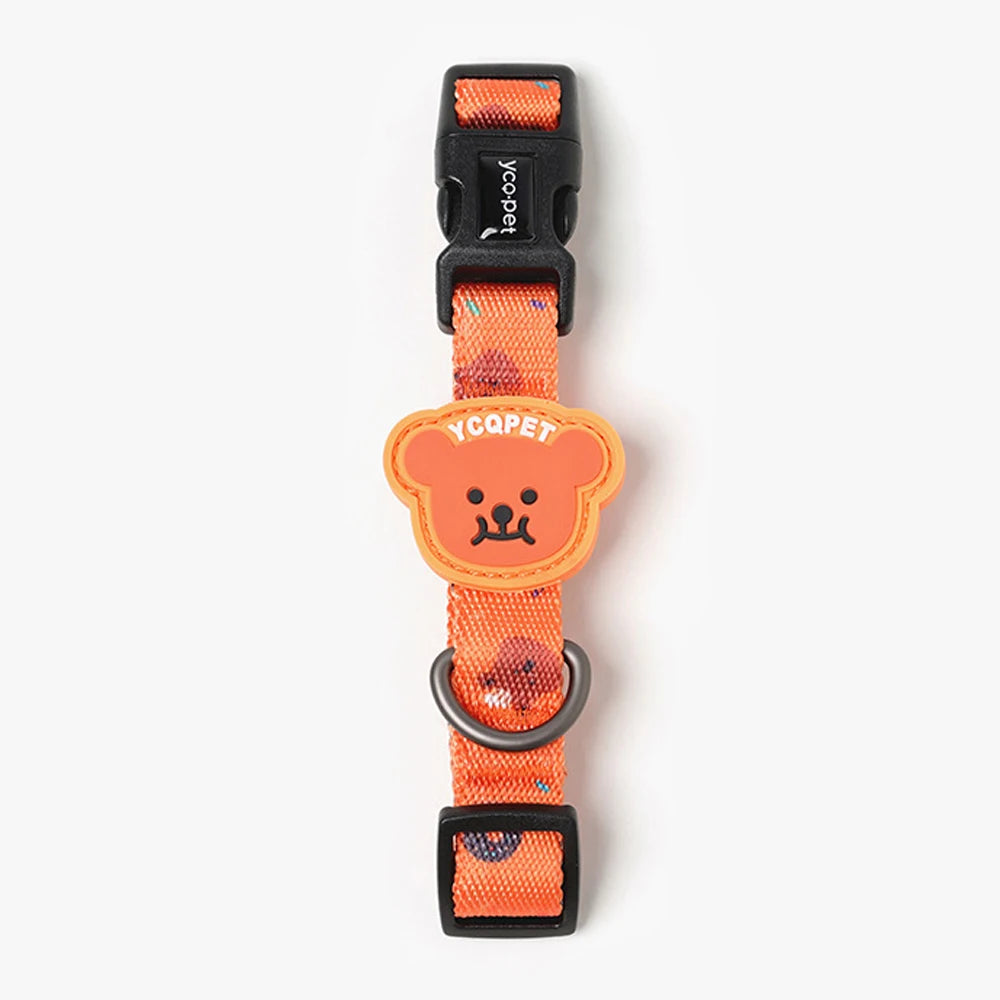 Vue de face du collier orange pour chiot avec motif ourson, boucle noire et badge ourson sur fond blanc.