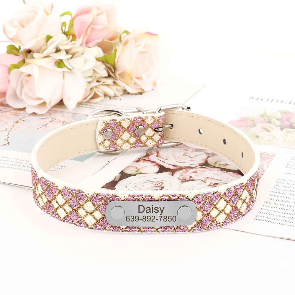 Collier crème et rose pour chiot avec plaque gravée présenté sur un support fleuri et des fleurs en arrière-plan.