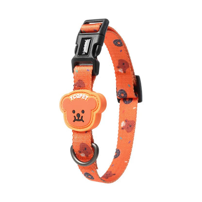 Collier orange pour chiot avec motif ourson, boucle noire et badge ourson sur fond blanc.