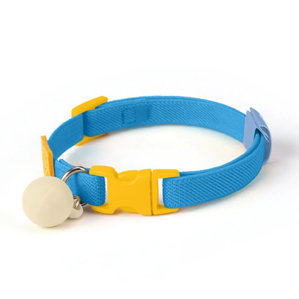 Collier bleu pour chiot avec boucle jaune et boule décorative beige sur fond blanc.