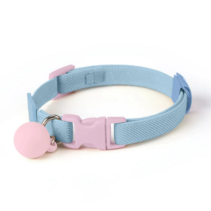 Collier bleu clair pour chiot avec boucle rose et boule décorative rose sur fond blanc.