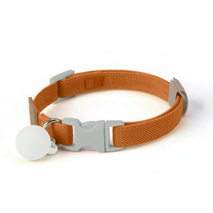 Collier marrron pour chiot avec boucle grise et boule décorative grise sur fond blanc.
