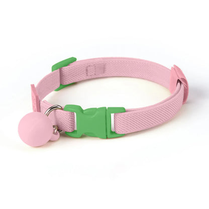 Collier rose pour chiot avec boucle verte et boule décorative rose sur fond blanc.
