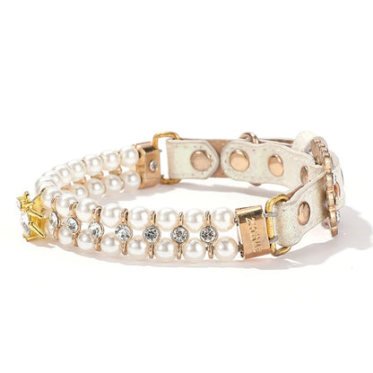 Vue de trois quarts d’un collier de luxe pour chien blanc avec perles artificielles et pendentif en cristal.