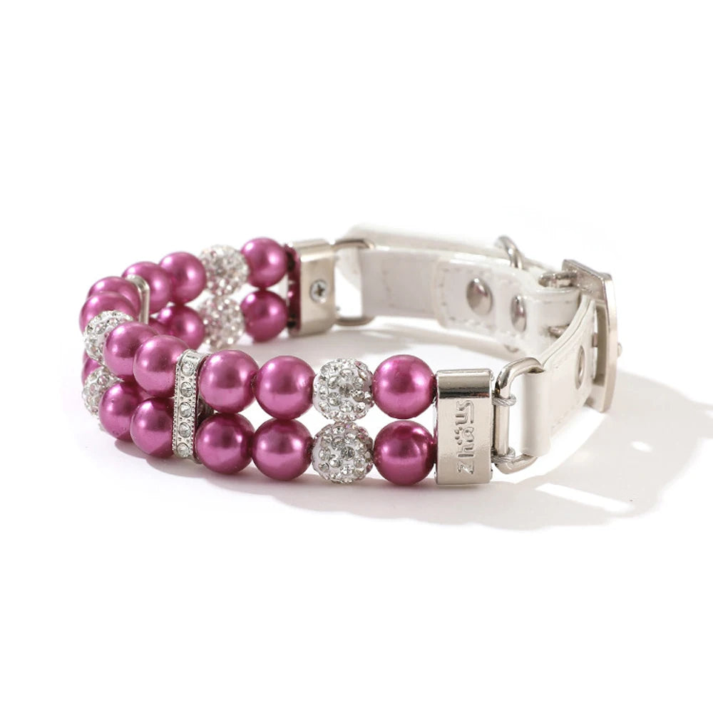 Collier de luxe pour chien à double rang de perles violet fuchsia avec strass scintillants sur fond clair.