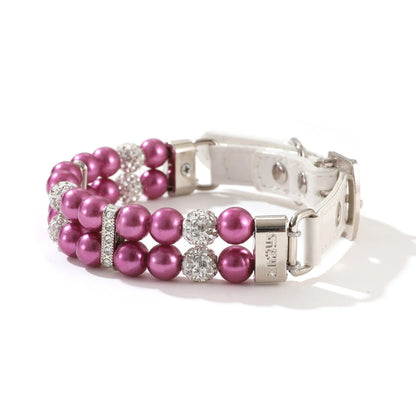 Collier de luxe pour chien à double rang de perles violet fuchsia avec strass scintillants sur fond clair.
