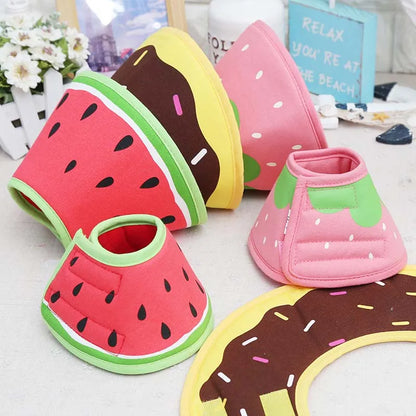 Plusieurs colliers lune légers en tissu pour chien avec motifs pastèque, fraise et donut posés sur une table