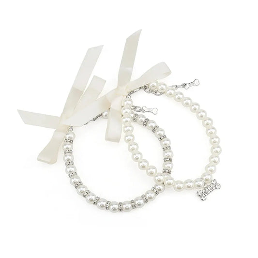 Deux colliers bijou pour chien en perles blanches avec ruban et pendentif os décoratif.