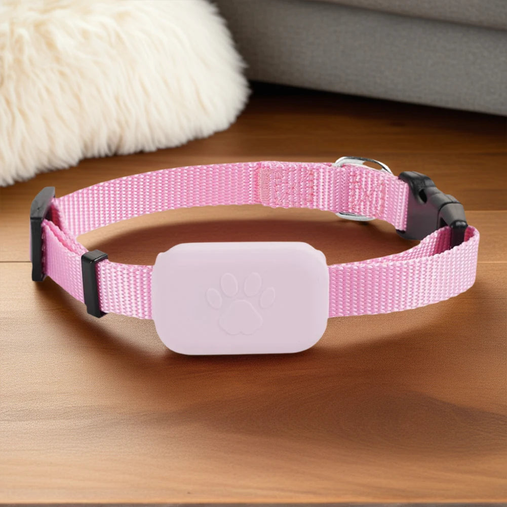 Collier de localisation rose pour chien présenté sur une surface en bois.