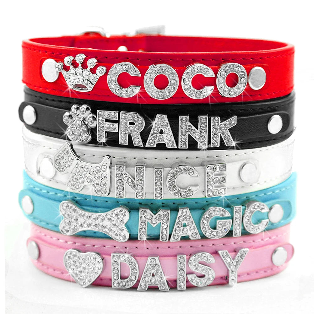 Colliers pour chien avec lettres en strass et symboles, empilés en vue frontale.