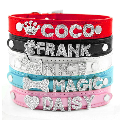 Colliers pour chien avec lettres en strass et symboles, empilés en vue frontale.
