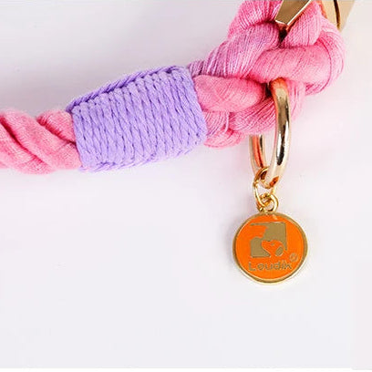 Zoom sur la finition dorée d’un collier en corde torsadée sur fond blanc.