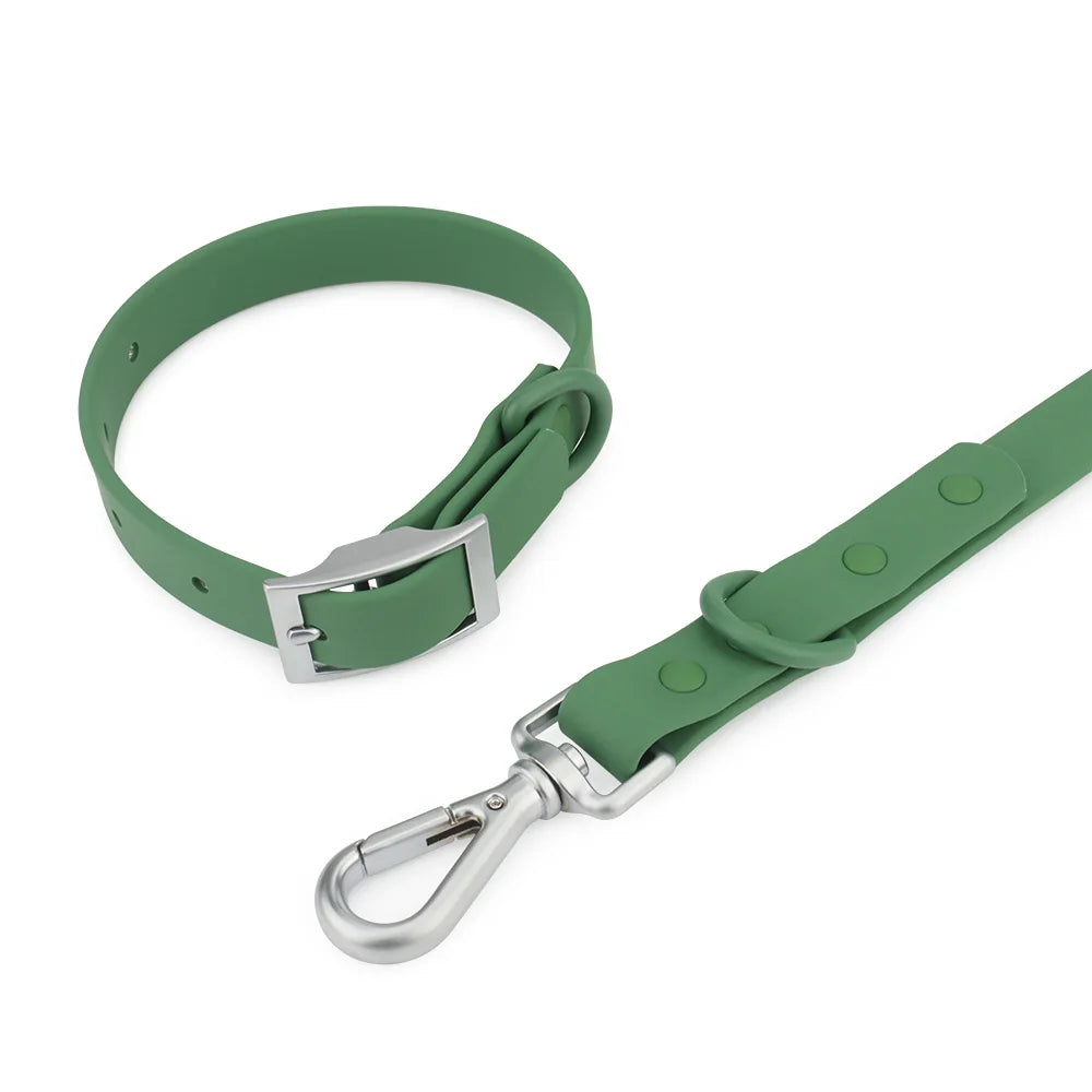 Gros plan sur la boucle et le mousqueton argentés d’un ensemble imperméable pour chien vert sur fond blanc.