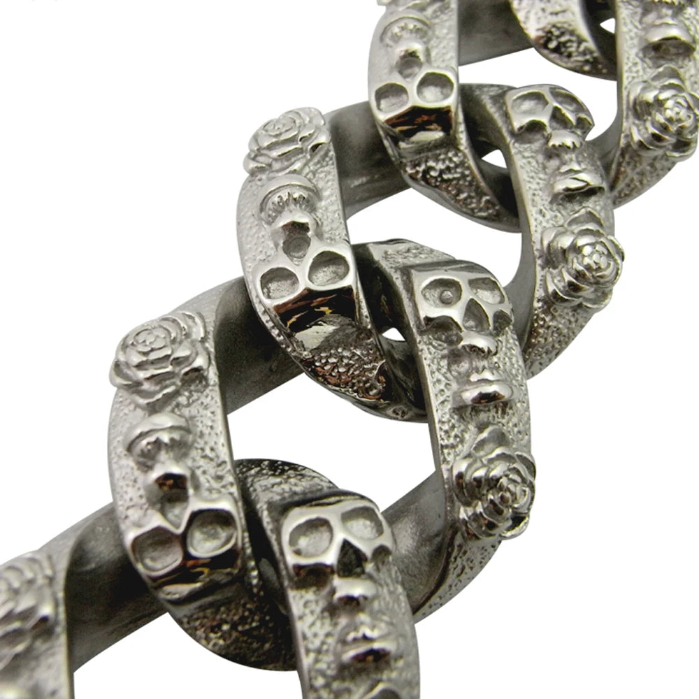 Détail des maillons argentés avec motif têtes et roses sur un collier chaîne pour chien sur fond blanc.
