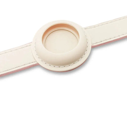 Gros plan sur le support AirTag intégré d’un collier fin en cuir rose pour chien.
