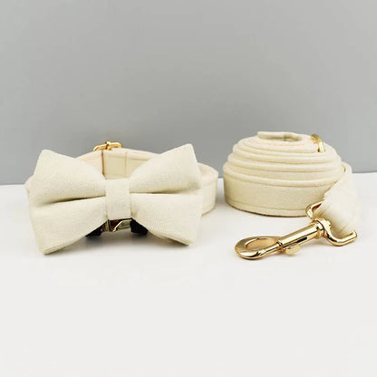 Ensemble collier et laisse pour chien en velours beige avec nœud papillon assorti.