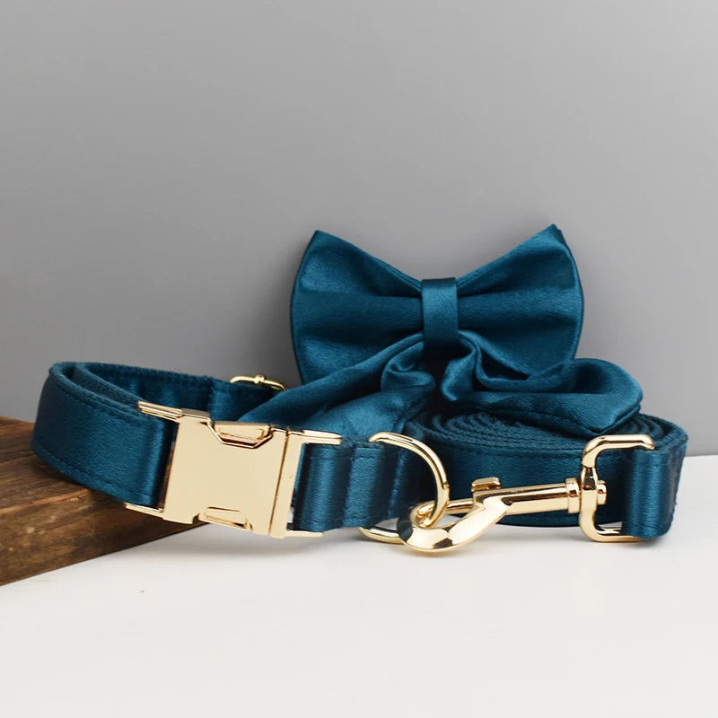 Ensemble collier et laisse pour chien bleu pétrole avec nœud détachable présenté sur un support en bois.