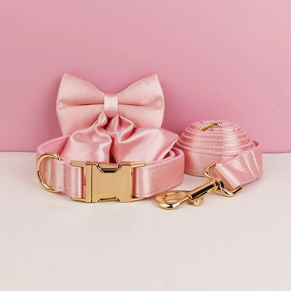 Ensemble collier et laisse pour chien rose avec nœud détachable présenté devant un fond rose et blanc.