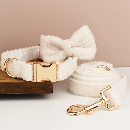 Ensemble collier, noeud papillon et laisse blanc pour chien en tissu bouclette présenté sur un support en bois.