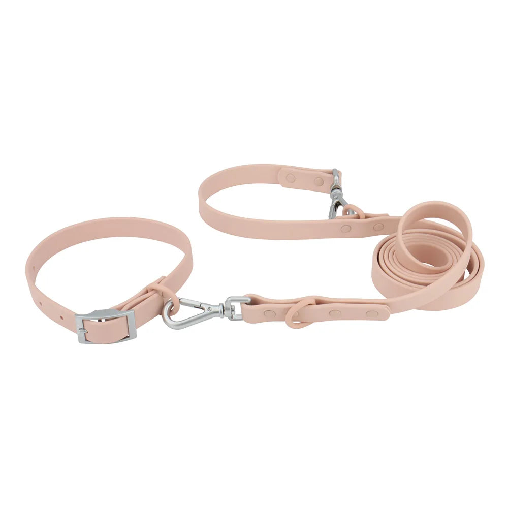 Ensemble collier et laisse imperméable pour chien en PVC rose avec bouclerie argentée.