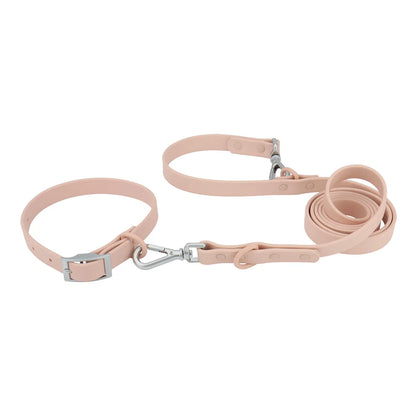 Ensemble collier et laisse imperméable pour chien en PVC rose avec bouclerie argentée.