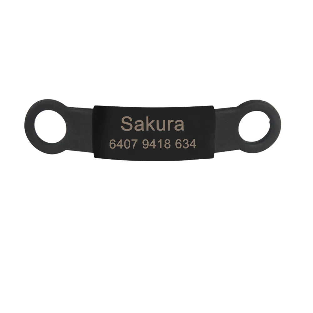 Étiquette noire personnalisée pour collier de chien avec gravure visible sur fond clair.