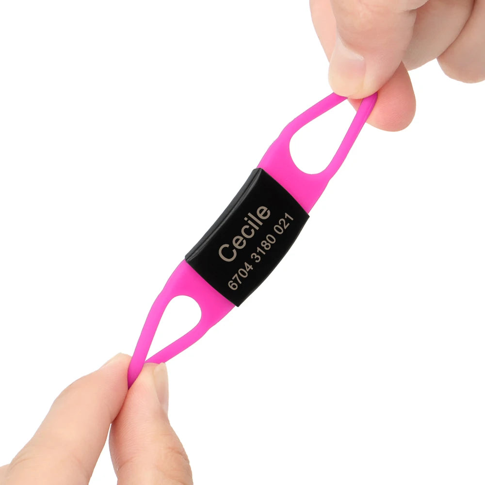 Étiquette personnalisée rose vif pour collier de chien tenue et étirée entre les doigts.