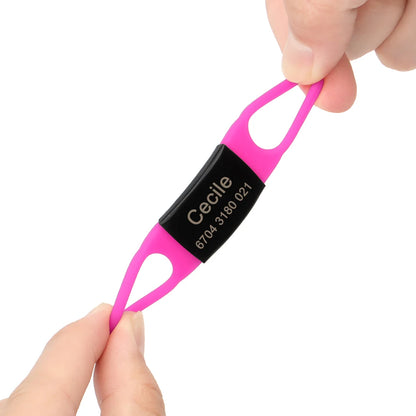 Étiquette personnalisée rose vif pour collier de chien tenue et étirée entre les doigts.