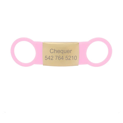 Étiquette rose clair pour collier de chien avec plaque dorée gravée Chequer sur fond blanc.
