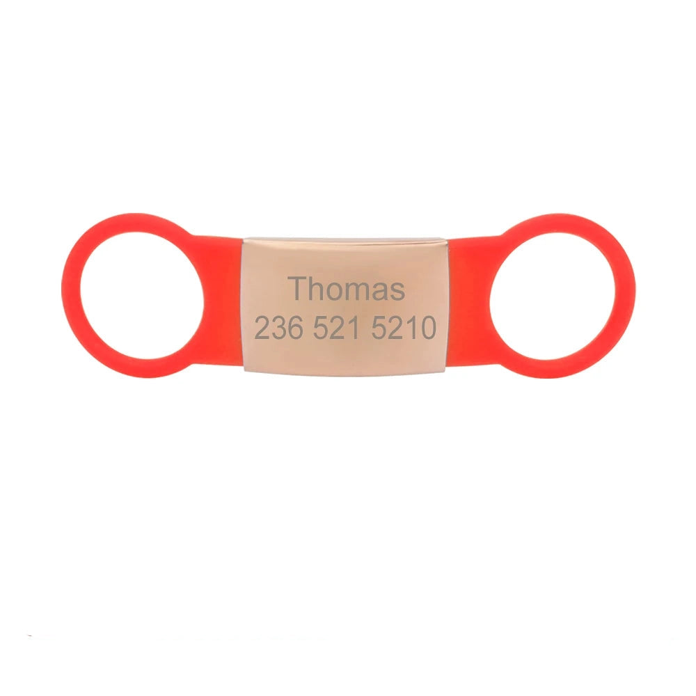 Étiquette rouge pour collier de chien avec plaque bronzée gravée Thomas sur fond blanc.