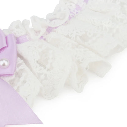 Détail de la dentelle blanche et d’un nœud lavande sur un collier chic pour chien.