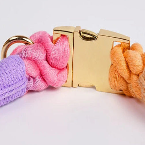 Gros plan sur le fermoir doré d’un collier en corde multicolore.