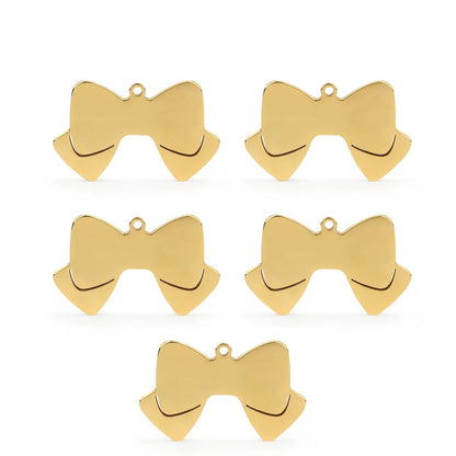 Lot de cinq pendentifs dorés en forme de nœud papillon sur fond blanc.