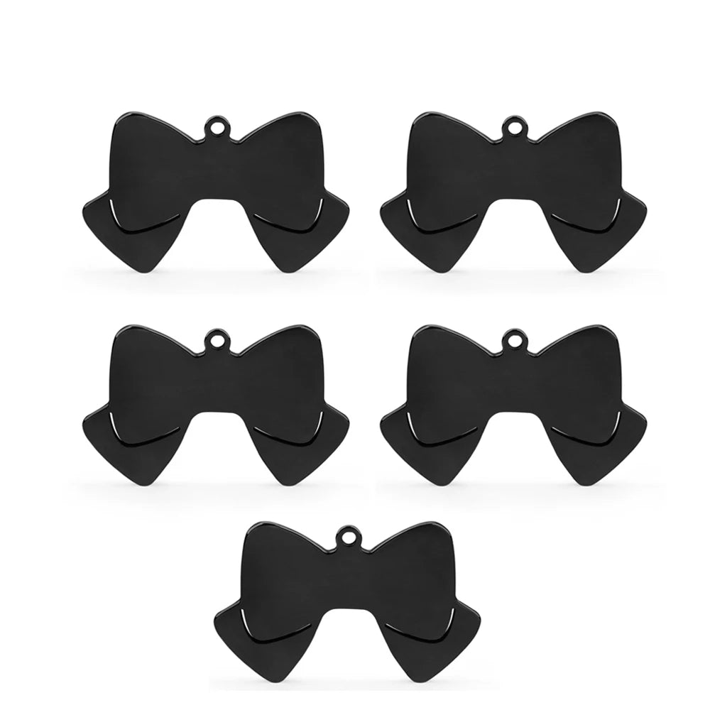 Lot de cinq pendentifs noir en forme de nœud papillon sur fond blanc.