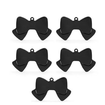 Lot de cinq pendentifs noir en forme de nœud papillon sur fond blanc.
