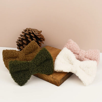 Plusieurs nœuds papillon détachables pour collier chien en tissu bouclette présentés sur un support en bois.